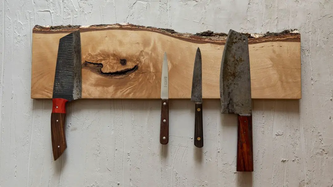 Four knives elegantly displayed on a wooden cutting board for a clever storage solution in the home.