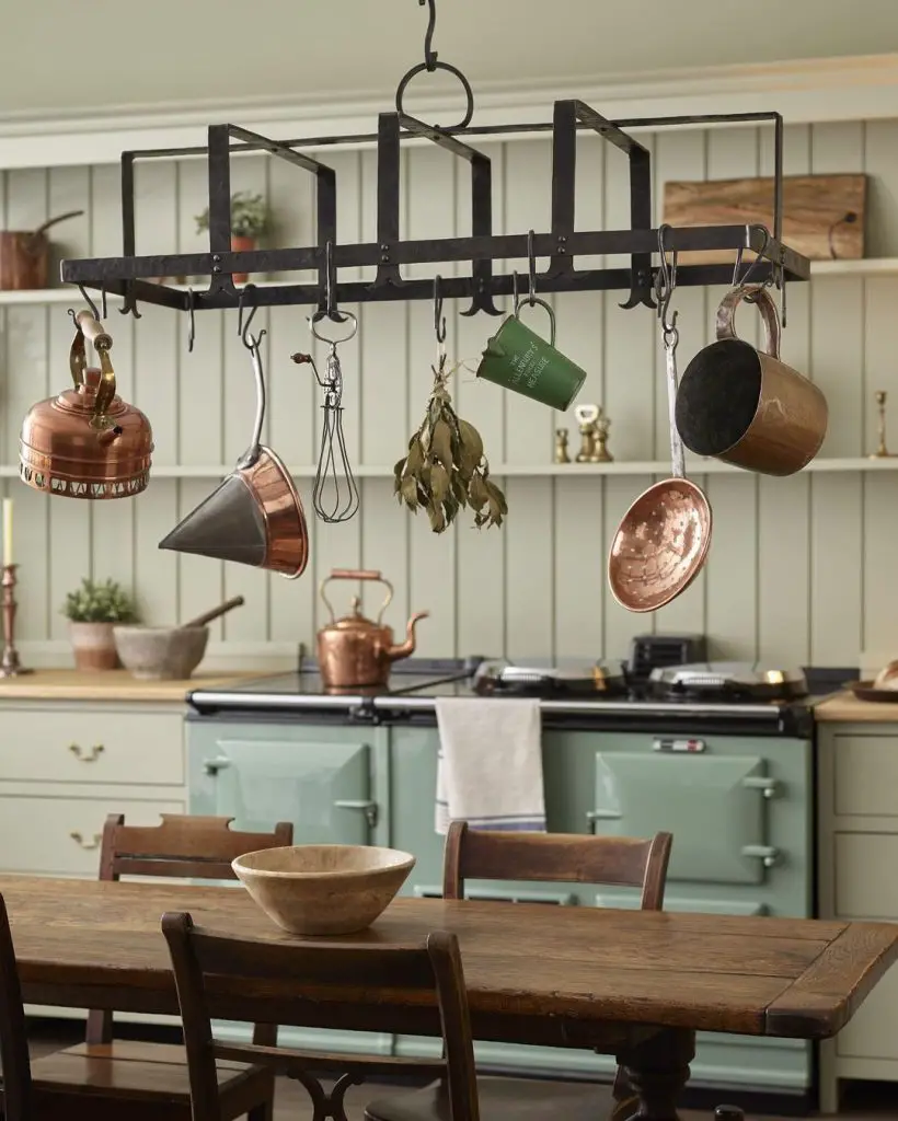 A kitchen with pots and pans cleverly hanging from the ceiling for efficient storage.