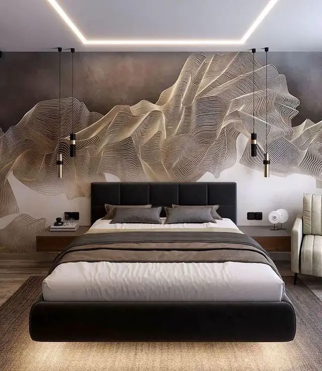 A modern bedroom featuring a large bed with neutral bedding, textured accent wall art, pendant lights, and subtle LED ceiling lighting.