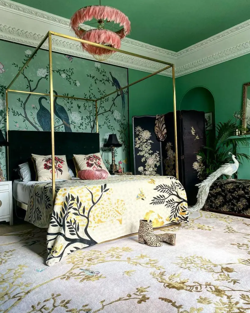 An opulent bedroom with a green wall, a four-poster bed with maximalist decor, a chandelier, and patterned accents.