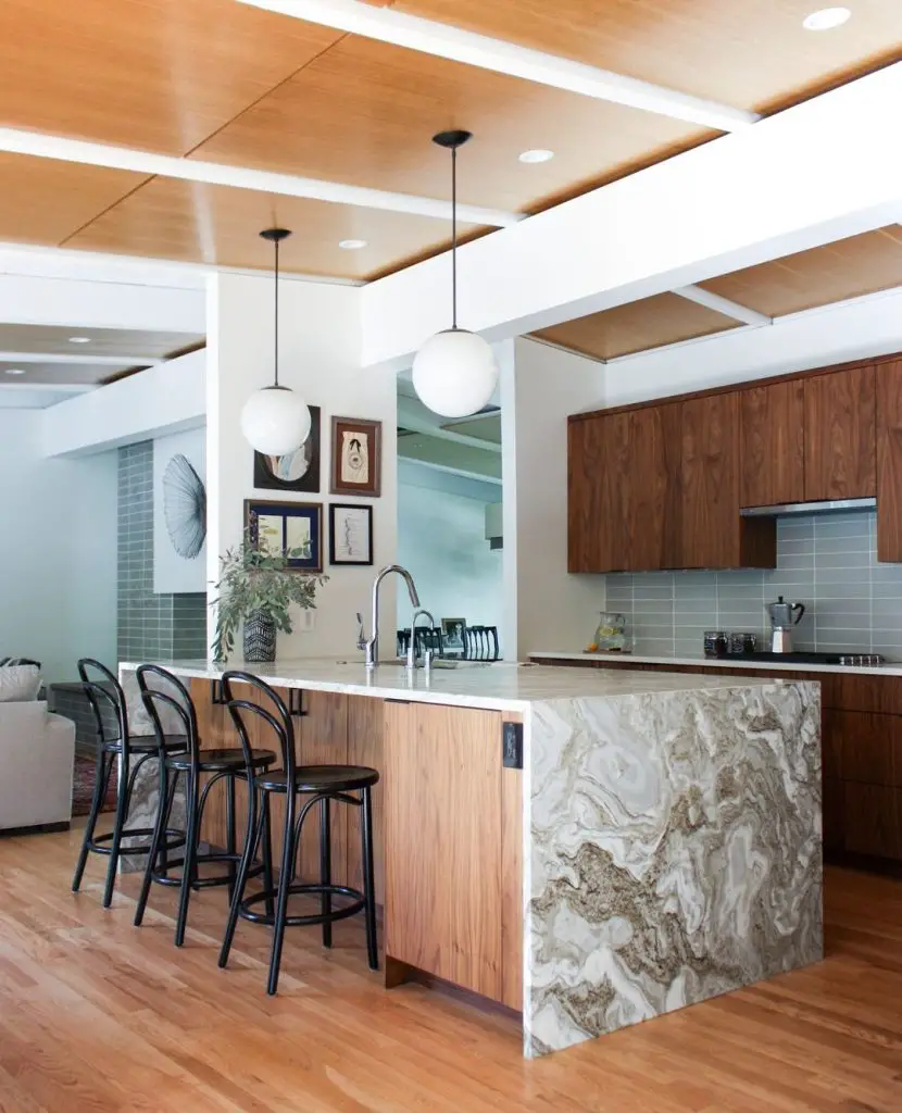 Modern kitchen with wooden cabinets, marble island, and pendant lights, featuring an open-plan layout that connects to the living area and incorporates Top 10 Timeless Mid-Century Kitchen Design Features.