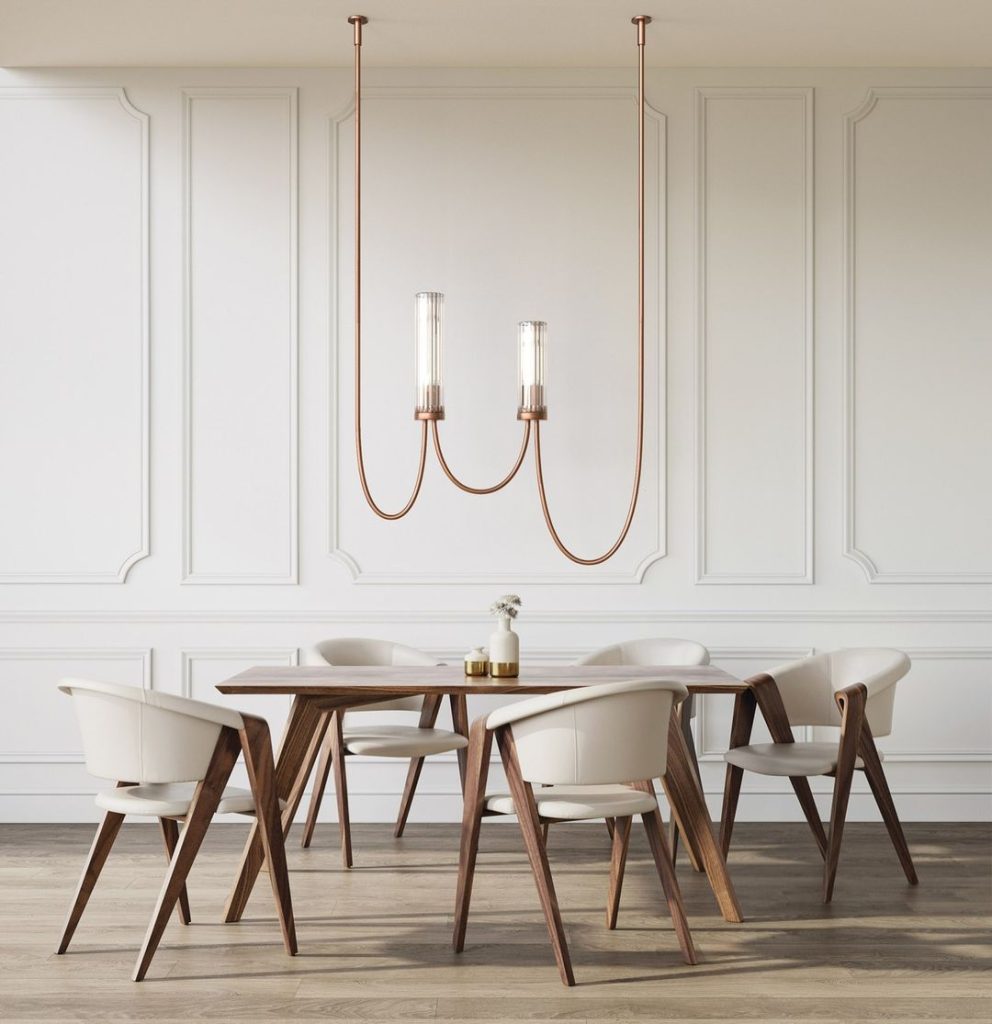 A minimalist dining room with a wooden table, white chairs, and two unique pendant lights hanging above for a warm and inviting ambiance.