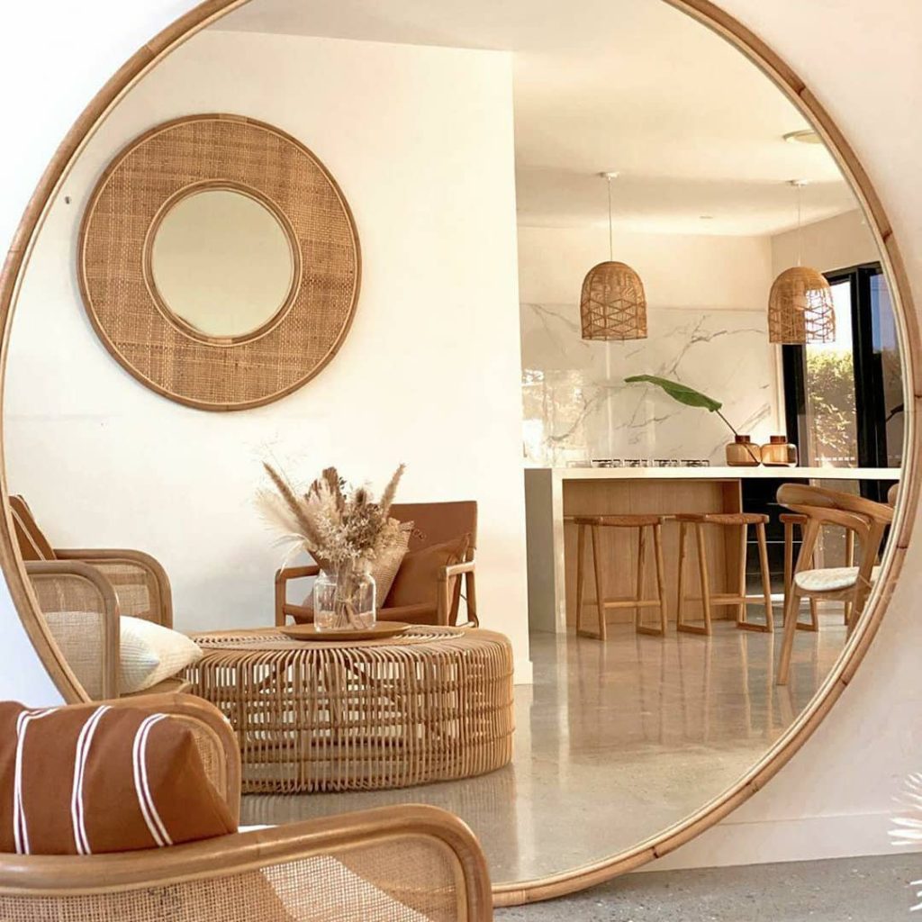 a large round statement framed mirror against a wall inside a living room