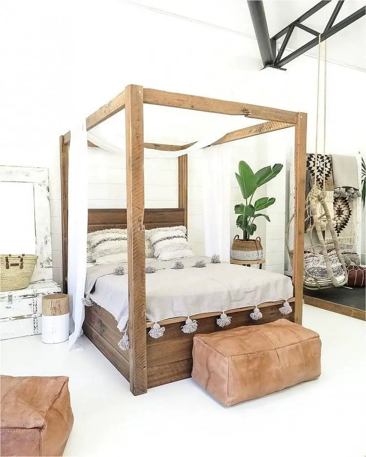 wooden canopy bed with warm bedding and throw pillows in a furnished bedroom