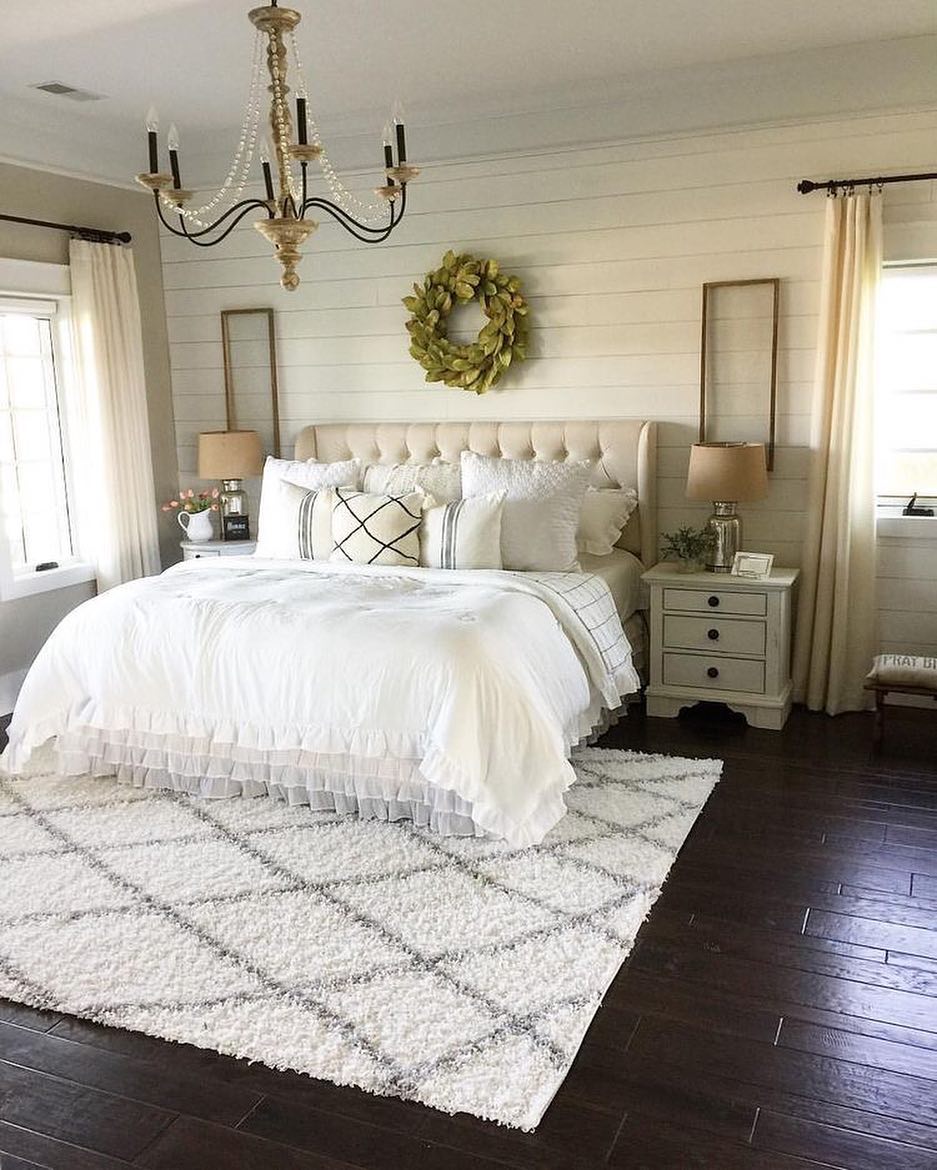 farmhouse inspired bedroom with a horizontal shiplap back wall, an elegant tufted upholstered bed, and ceiling light along with a fluffy area rug under the bed