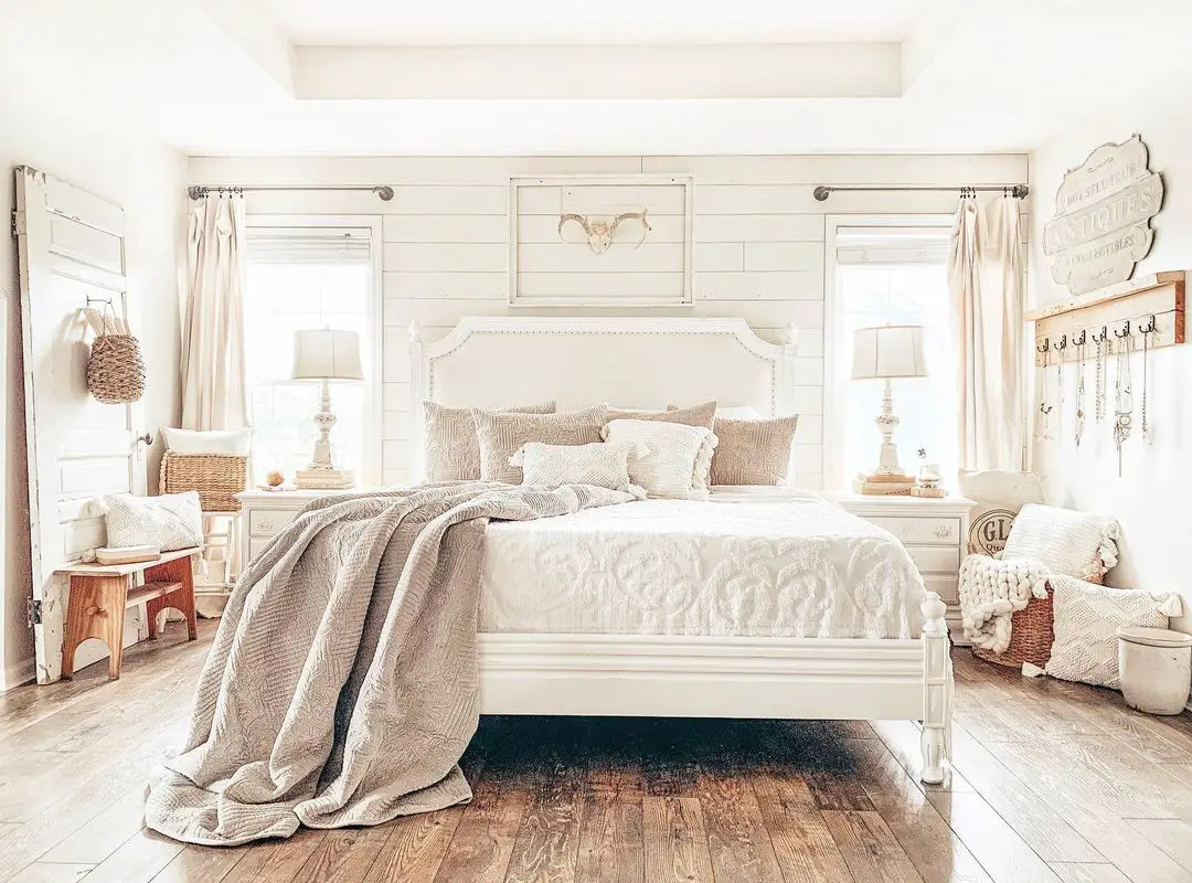 wood is the main material in this rustic inspired bedroom all in white furnished with a large bed and two bedside tables with lamps 