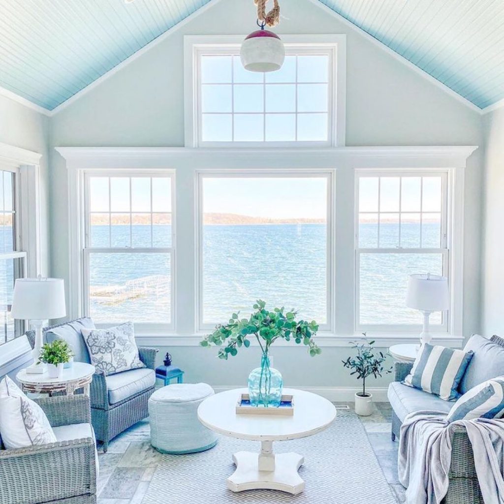 coastal themed living room interior with windows overlooking the sea