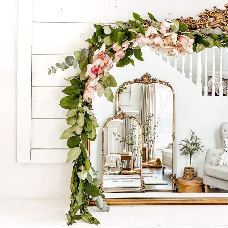 gold framed mirrors on the floor against the wall and stair balustrade in the background