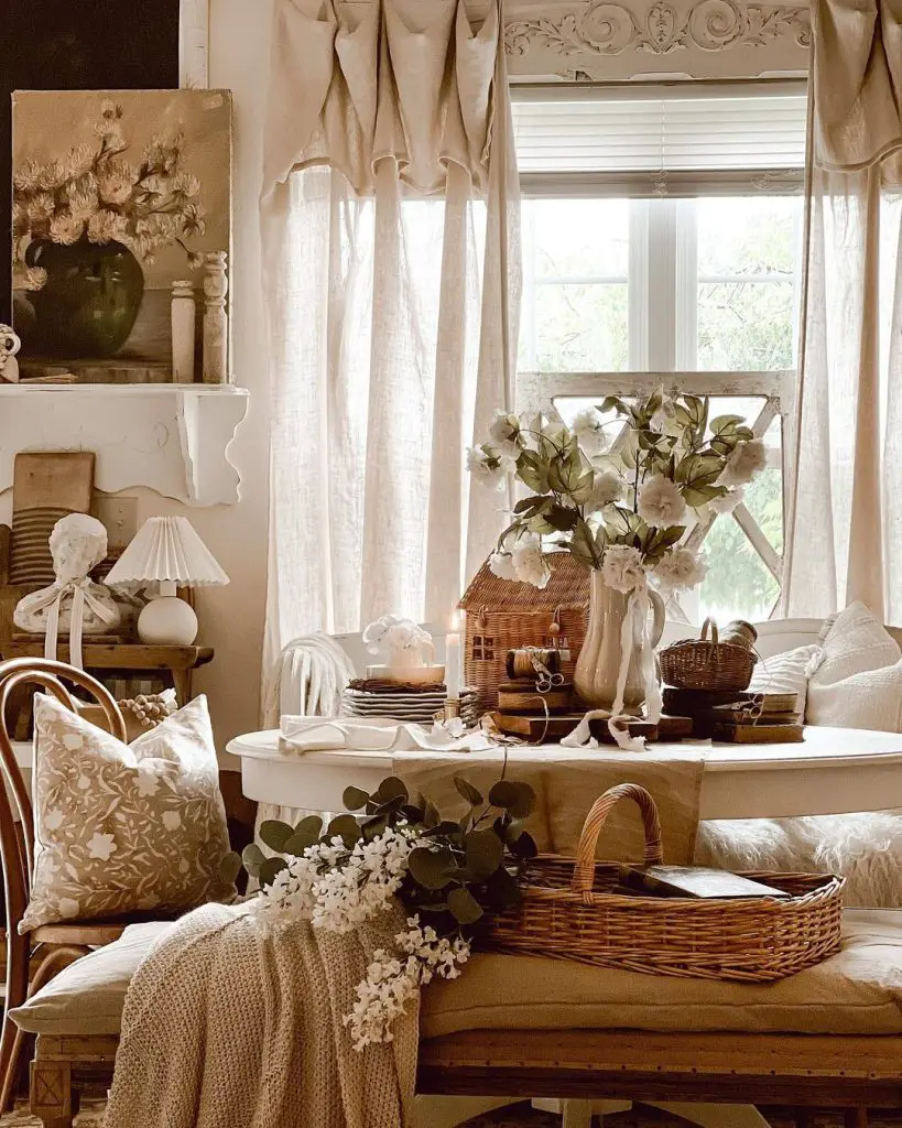a bench and a table styled with a gorgeous stoneware pitcher, wooden spools and florals in a rustic farmhouse room