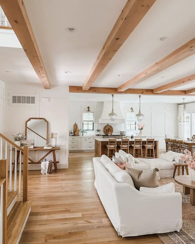open layout living room, kitchen, and dining area with exposed wood ceiling beams