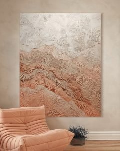 How can you embrace creative ideas beyond paint and wallpaper? Consider a textured abstract wall art with a landscape pattern in earthy tones, hanging on a beige wall above a peach-colored cushioned chair and a small plant.