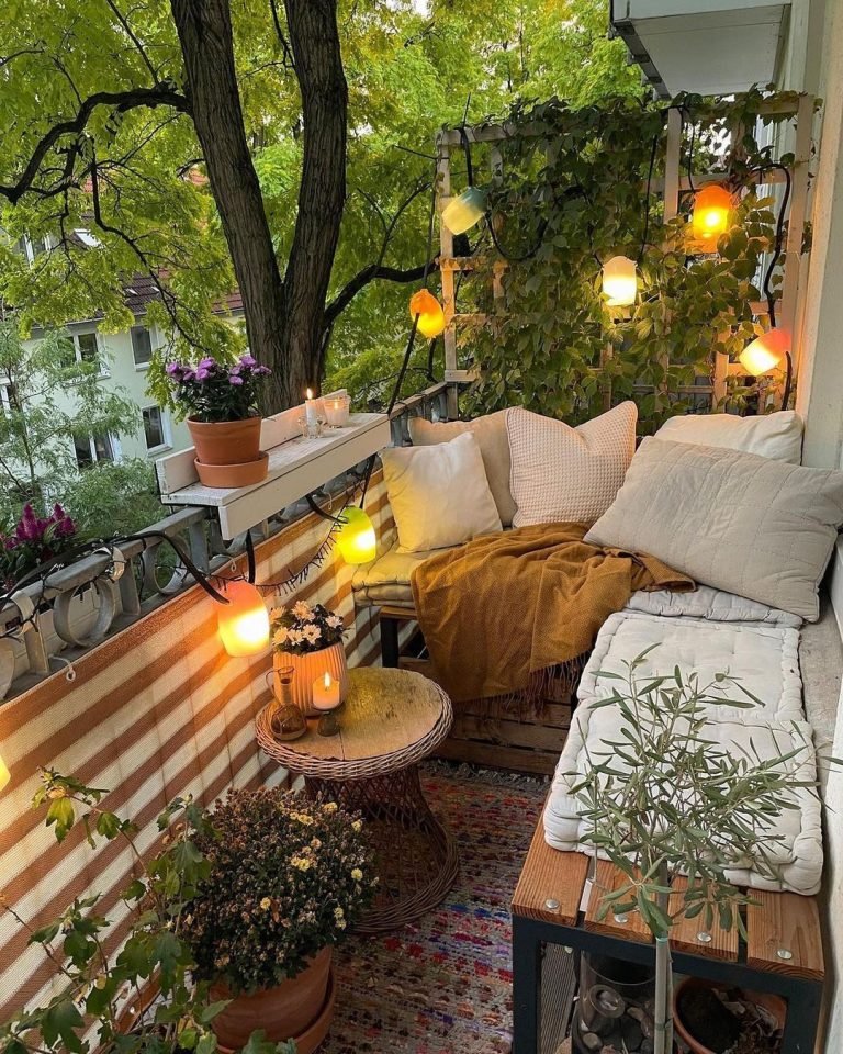 a Tiny Balcony with wooden benches, throw pillows, a small round patio table, and hanging lights