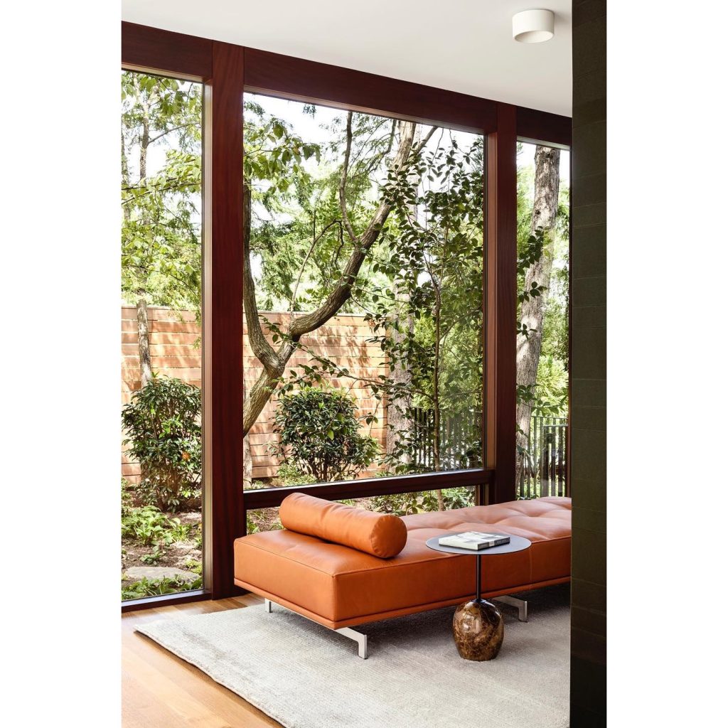 a Meditation Sunroom with a backless couch and a large glazed window