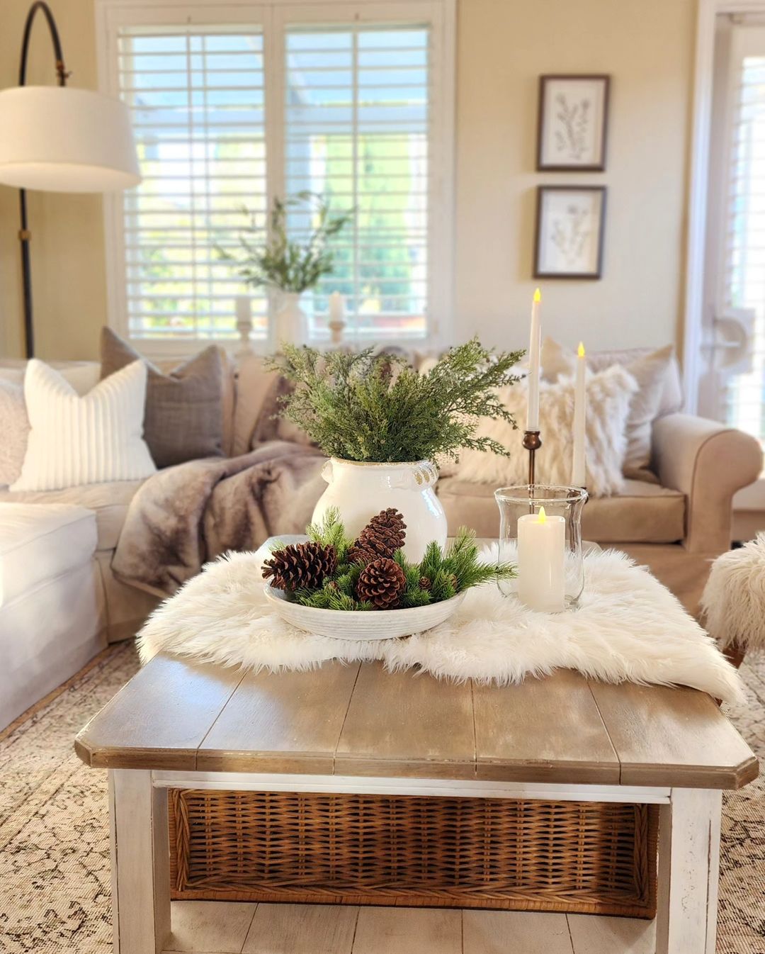 centrepiece with natural winter decor elements like pinecones and a candle can add an uplifting winter vibe to any living space as this one