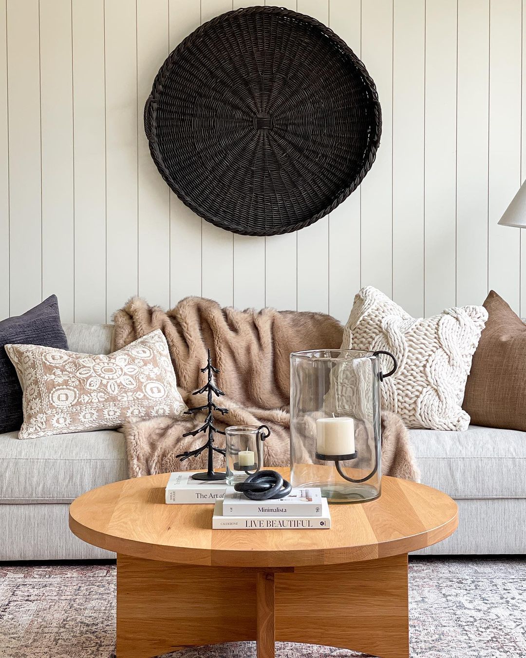 couch with winter style throw pillows and blankets with a wood shiplap back wall and a wooden coffee table 