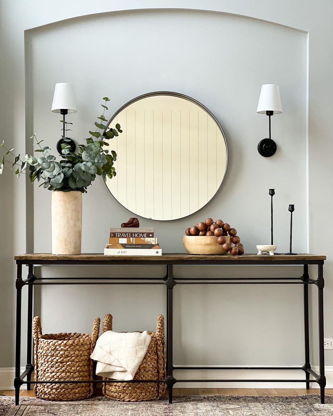 entryway console table with metal legs and round mirror on the background wall