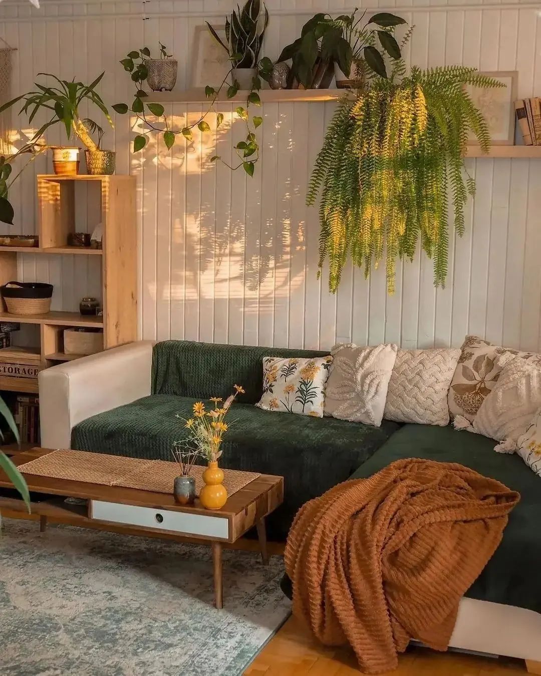 couch with throw pillows and a blanket, and plants including foliage above to add life to this bohemian_inspired interior