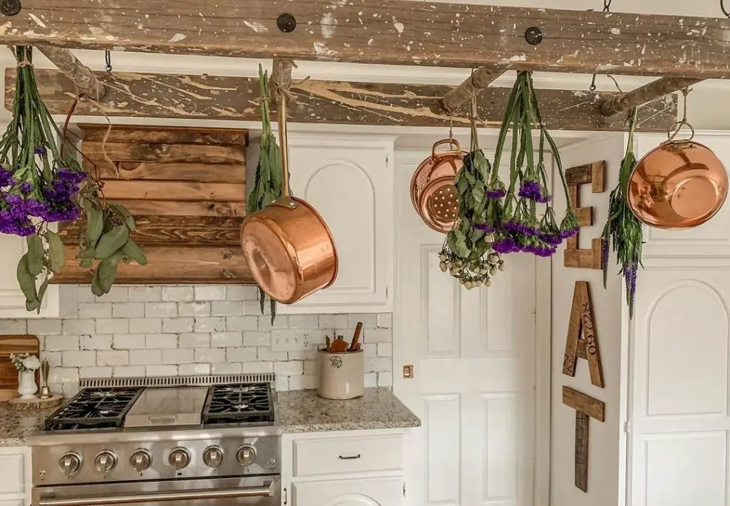 a handing wooden ladder used creatively to store pots and pans in a kitchen within easy reach