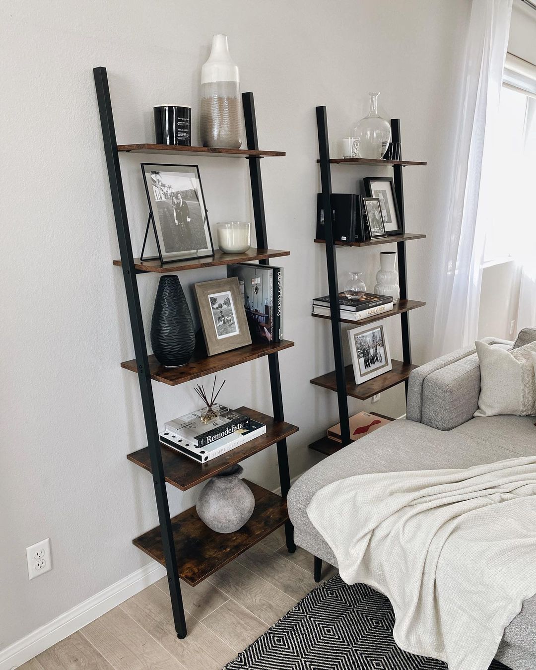 two ladder-bookshelves provide way more display space than one and looks balanced when they're styled next to each other in a living room