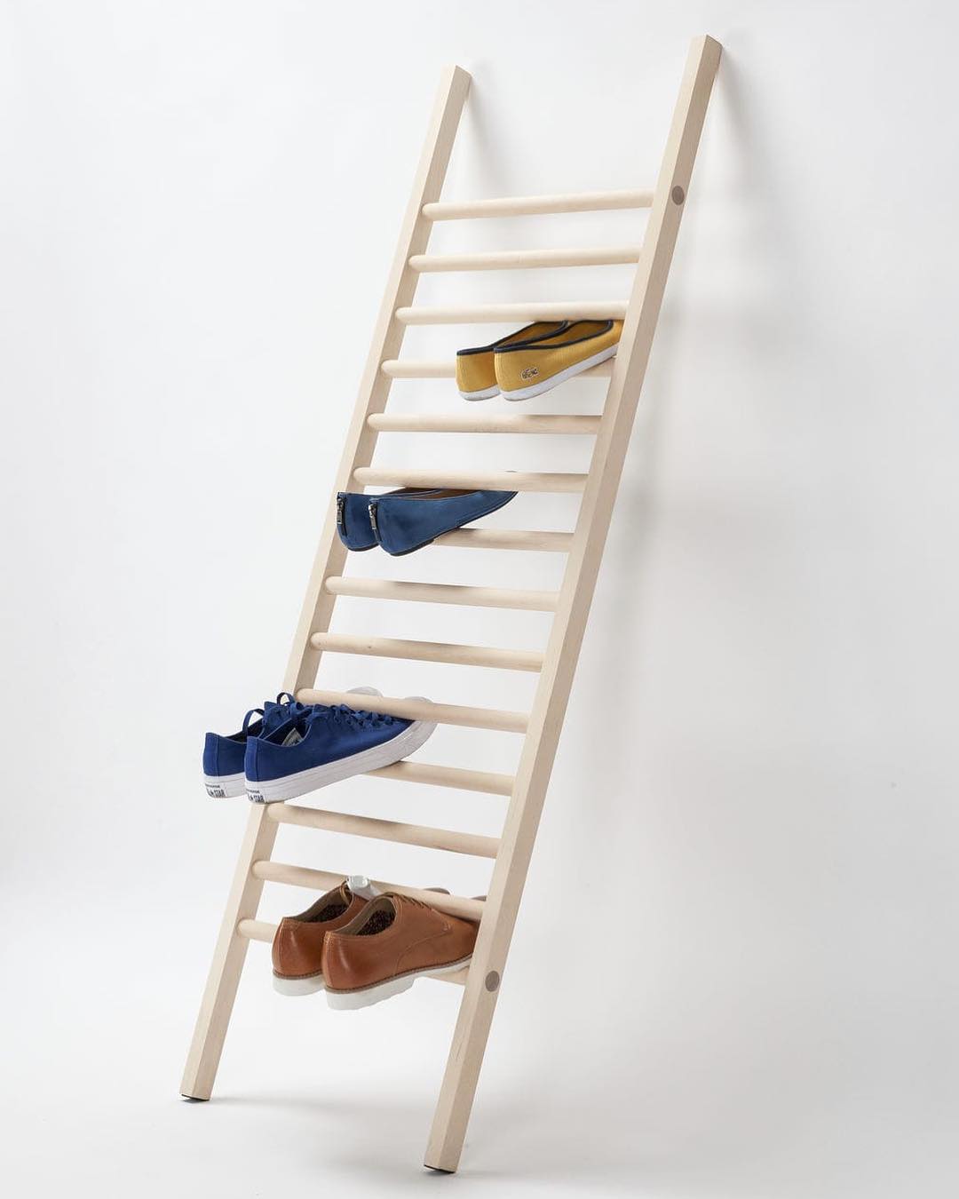 a wooden ladder leaning against a blank wall to hold shoes is a simple yet effective way to store shoes vertically
