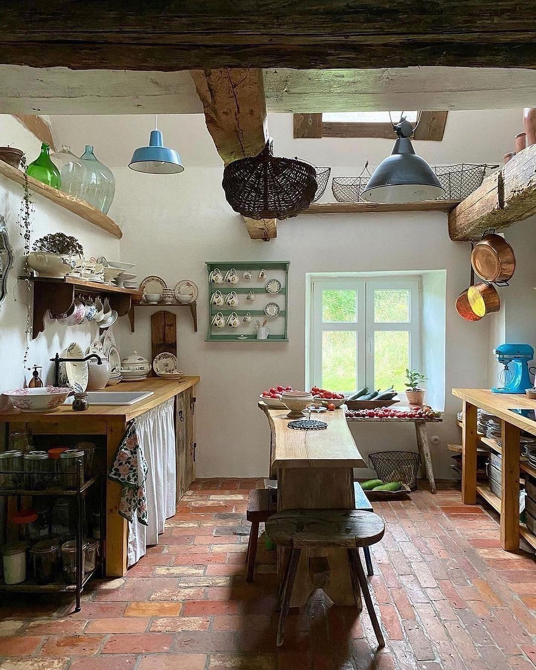 a rustic kitchen uses humble materials such as natural distressed wood, clay, and metal