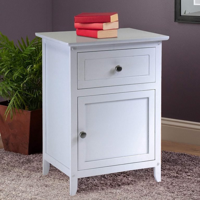 wooden cabinet in white with books on the top and potted plant decor on the floor