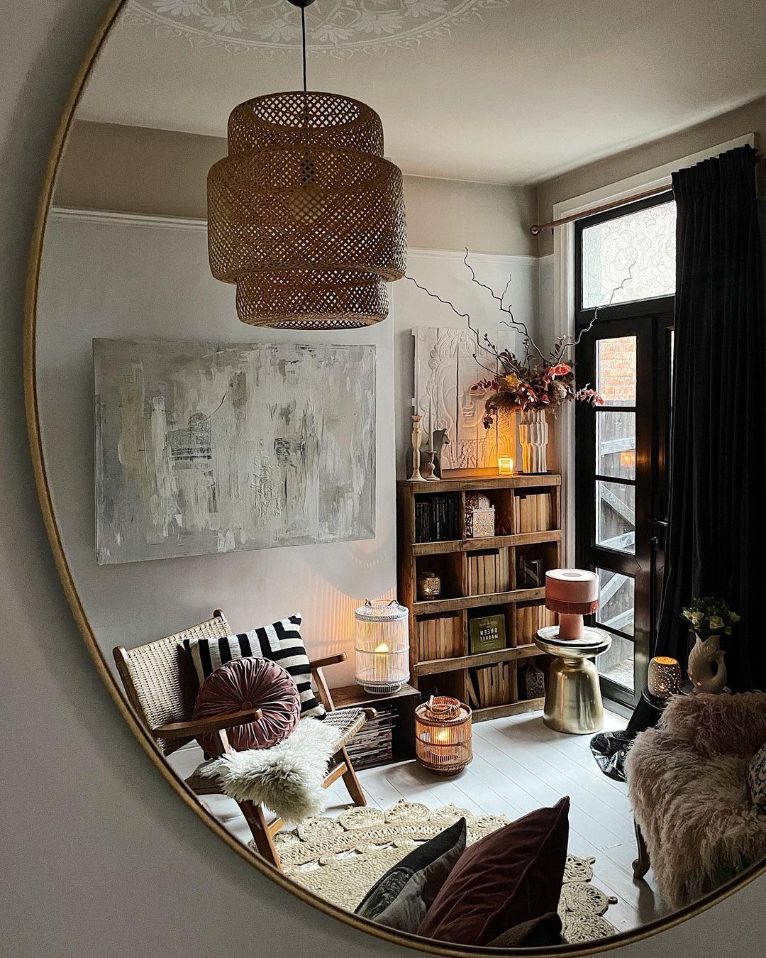 the reflection of a bohemian living room as seen through a round wall mirror.