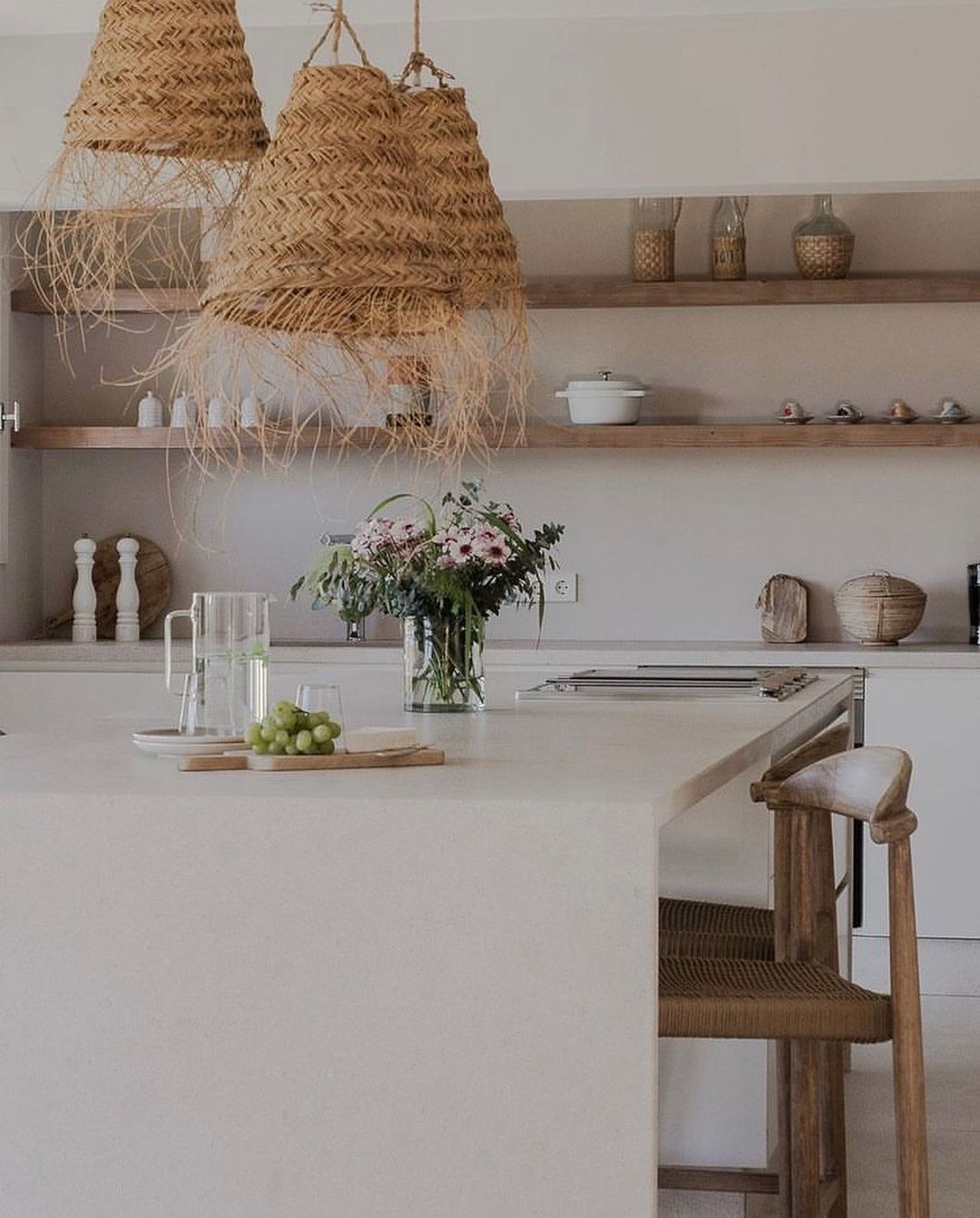 a minimalist style kitchen with bohemian inspired rattan pendant lights to bring a relaxed feel to the space