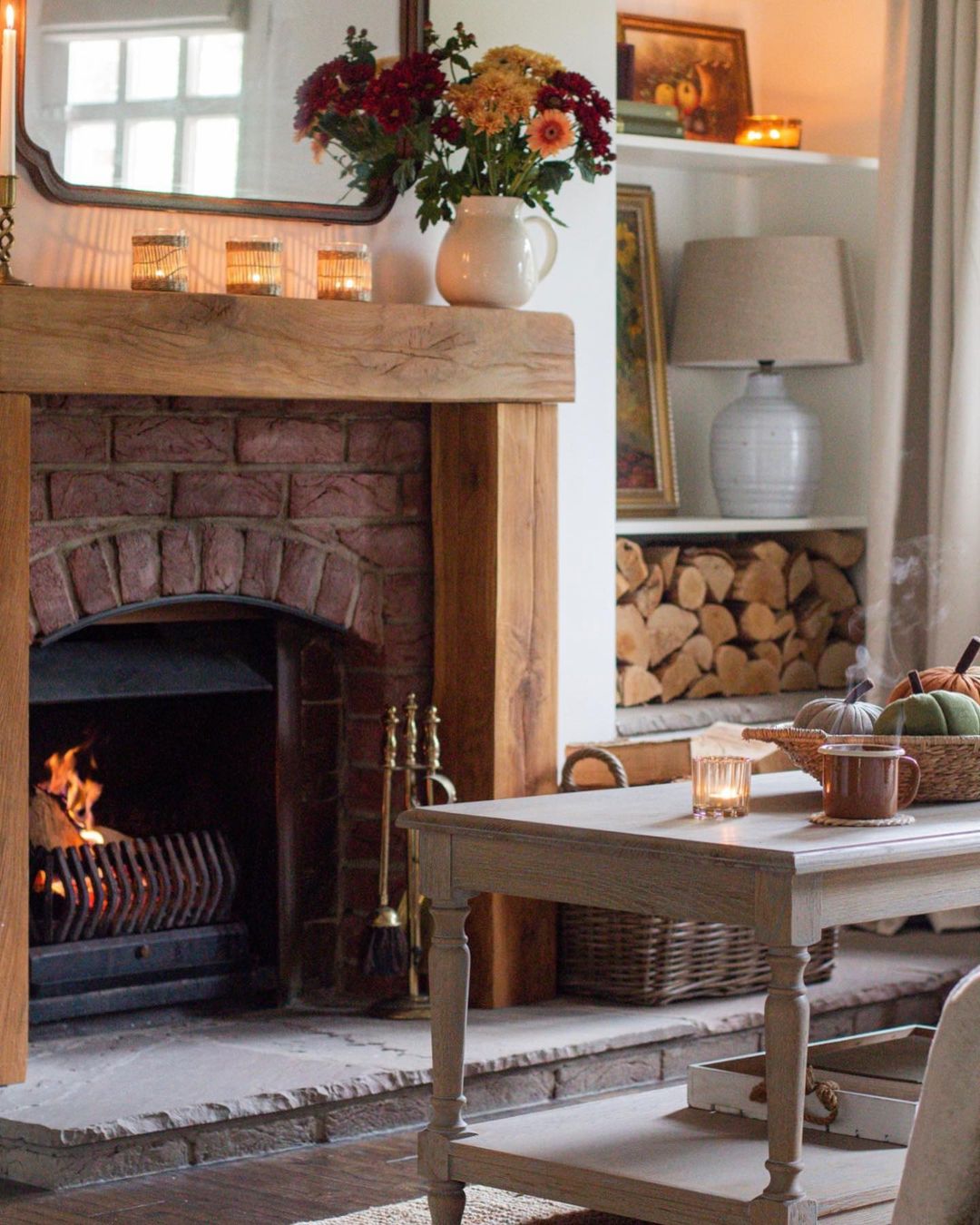 a red brick fireplace and wooden frame and furniture are what makes this living room interior exhibit a cottage feel