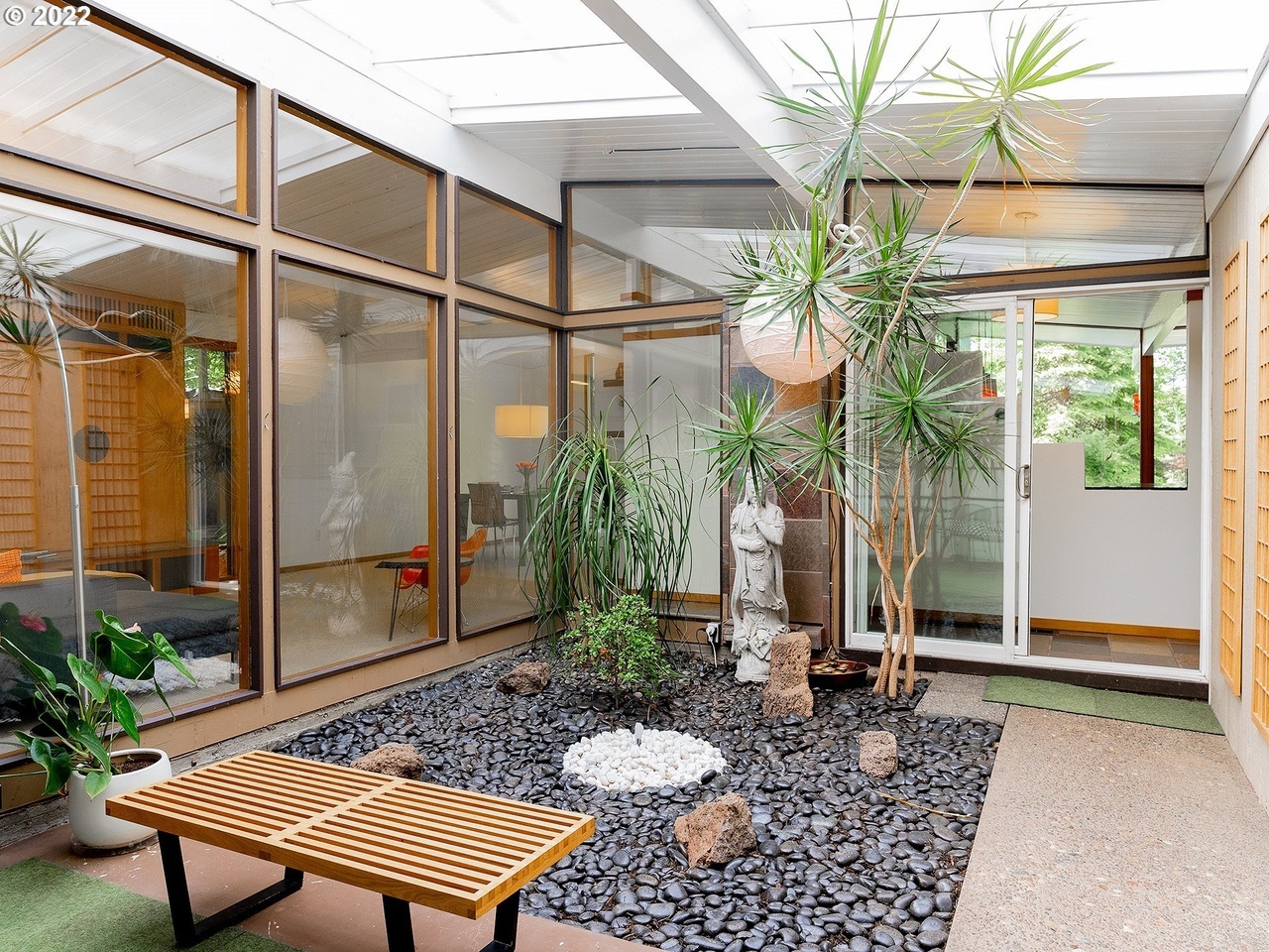 an indoor covered courtyard home garden space with water fountain and plants