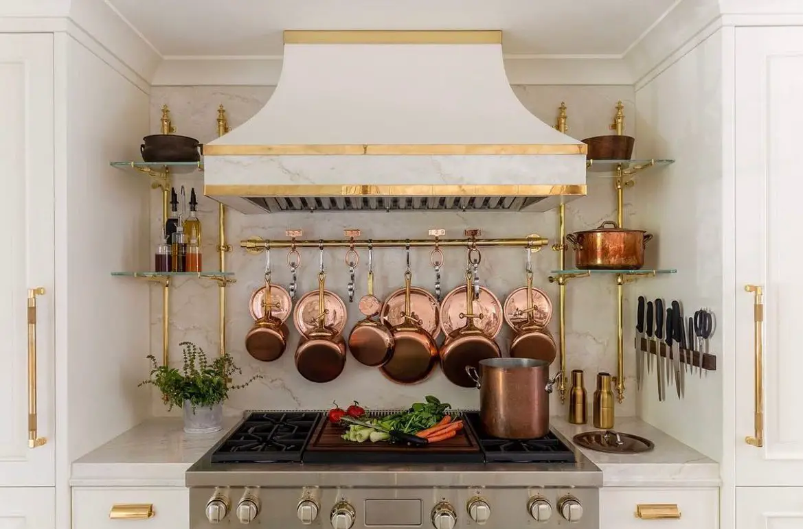 a wall-mounted pot rack above the stove is a great way to utilize unused wall space while conveniently storing pots and pans for easy reach.