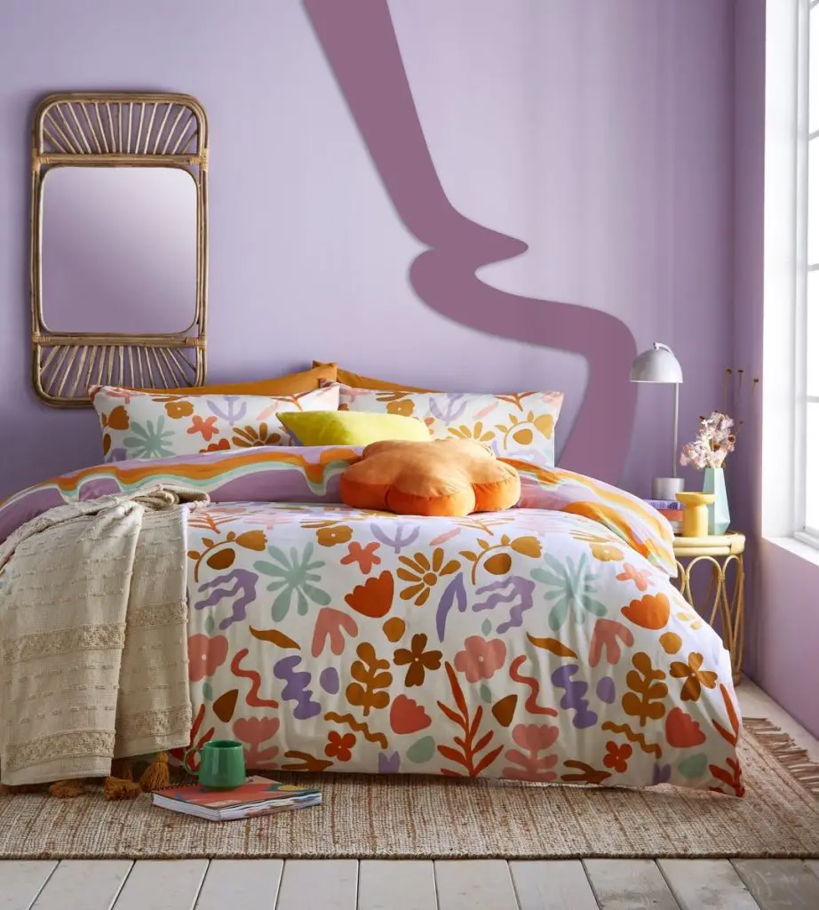 colorful and bright abstract florals bedding patterns together with colorful wall decor are the main decor strategies for this funky bedroom.