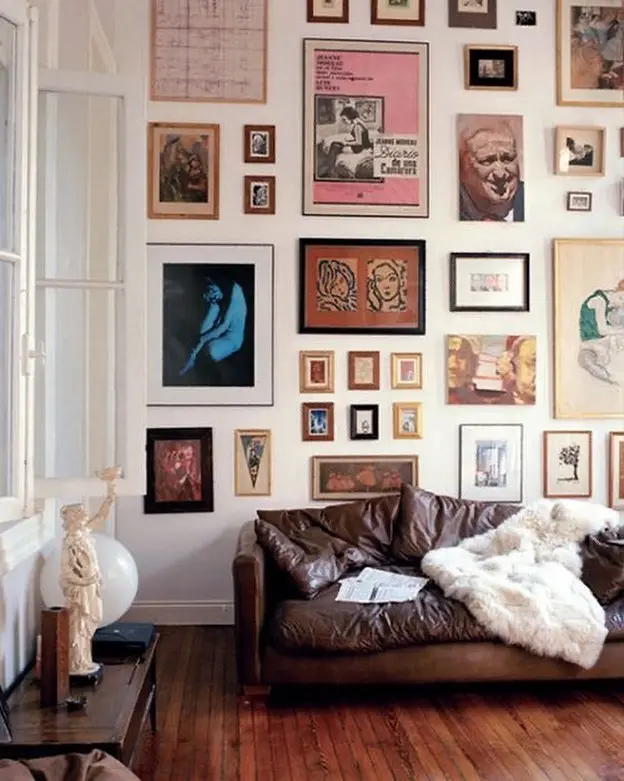 a maximalist gallery of wall art in a living room provides the perfect backdrop and depth to an otherwise plain wall.