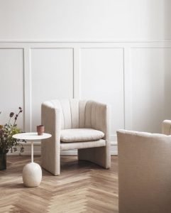 it's important to choose and pair a small side table to a sofa in order to complement the overall decor of a living room rather than to compete with it.