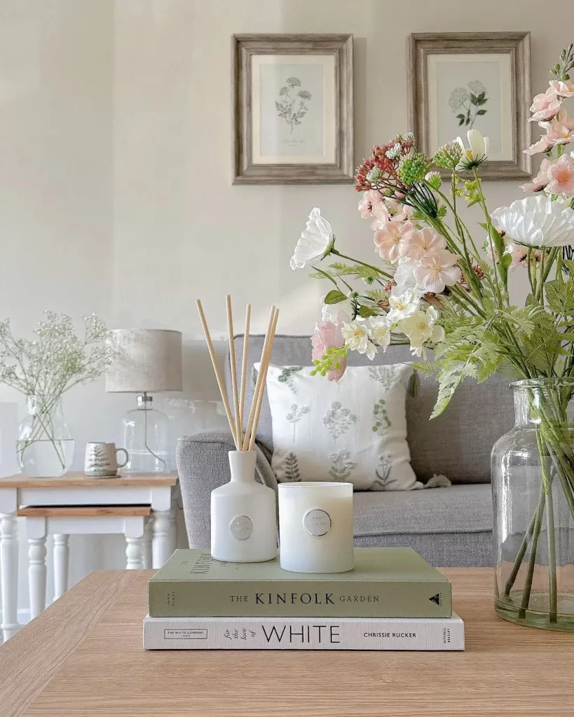 there are different ways to add texture and materials to your summer living room decor and one way is to consider textured pillows and adding natural elements like fresh plants to style your coffee table.