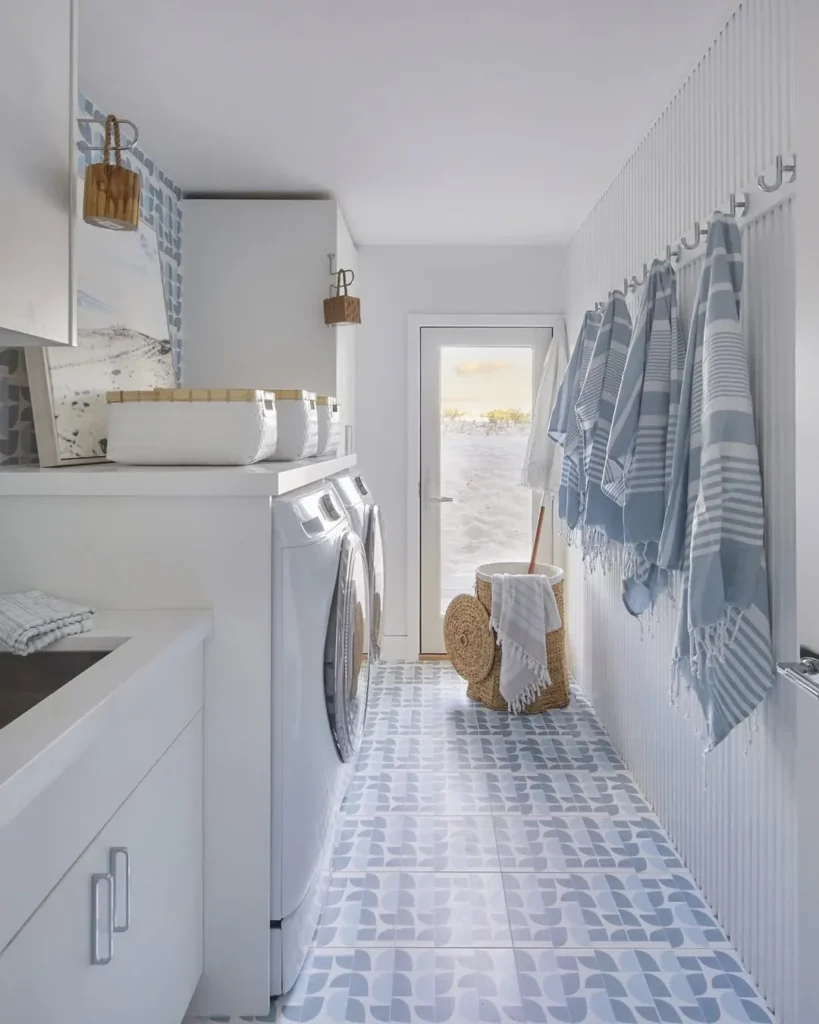 a coastal-inspired laundry with light blue and white color palette and a beautiful woven laundry basket complements the decor by adding texture