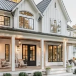 front porch of a white farmhouse with ambient lights on during daytime