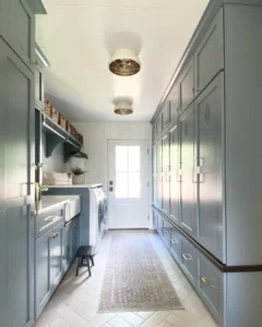 a mudroom that incorporate a laundry can make a great combo for efficiency and creative design opportunities as with the blue painted cabinets on both sides of this room