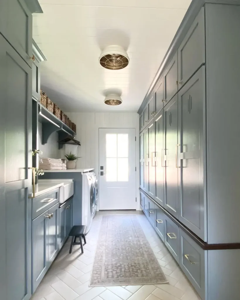 a mudroom that incorporate a laundry can make a great combo for efficiency and creative design opportunities as with the blue painted cabinets on both sides of this room