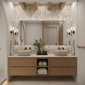 Organic Modern Bathroom featuring double stone sinks, wood vanity, wall-mounted faucets, large mirror, and a stone accent wall; rolled towels and decor are neatly arranged on open shelves below.