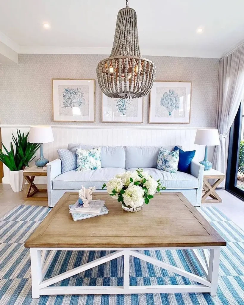 nautical stripped rug, wood furniture, natural light, and beach-themed wall art turned this space into a summer-beach-styled living room