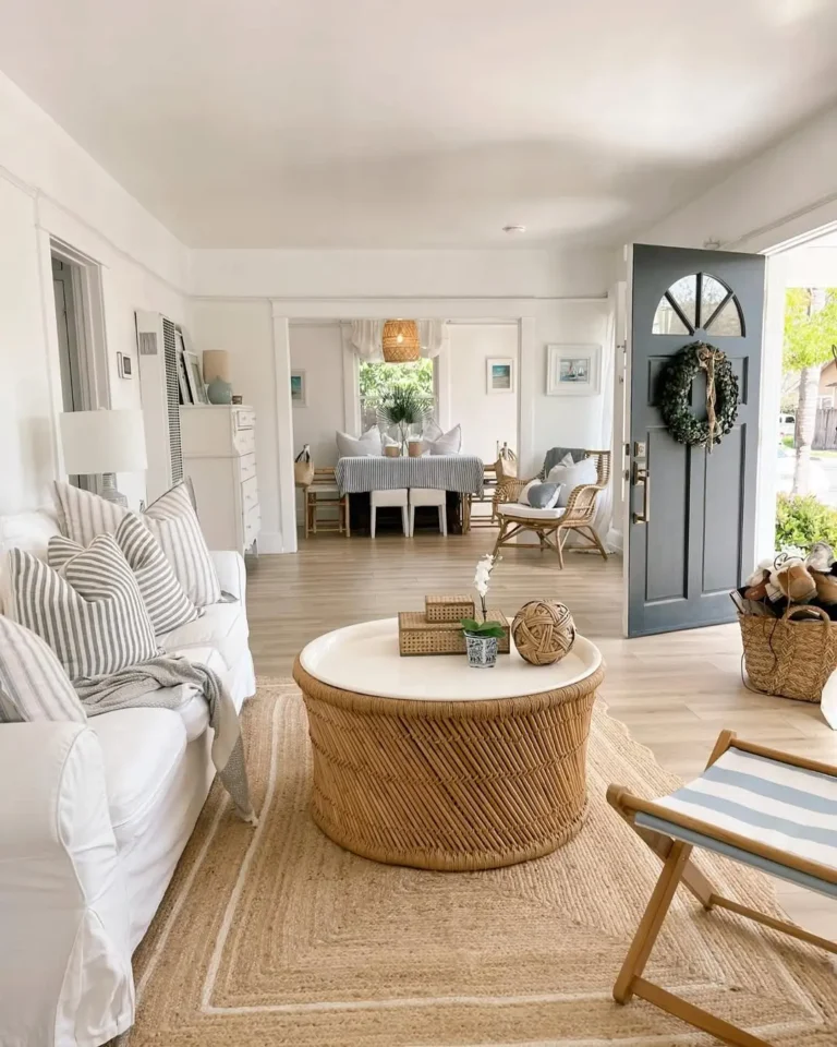 a light, bright, and airy living room interior with the perfect summer coastal decor vibe with a slipcover sofa, jute rug, and rattan coffee table