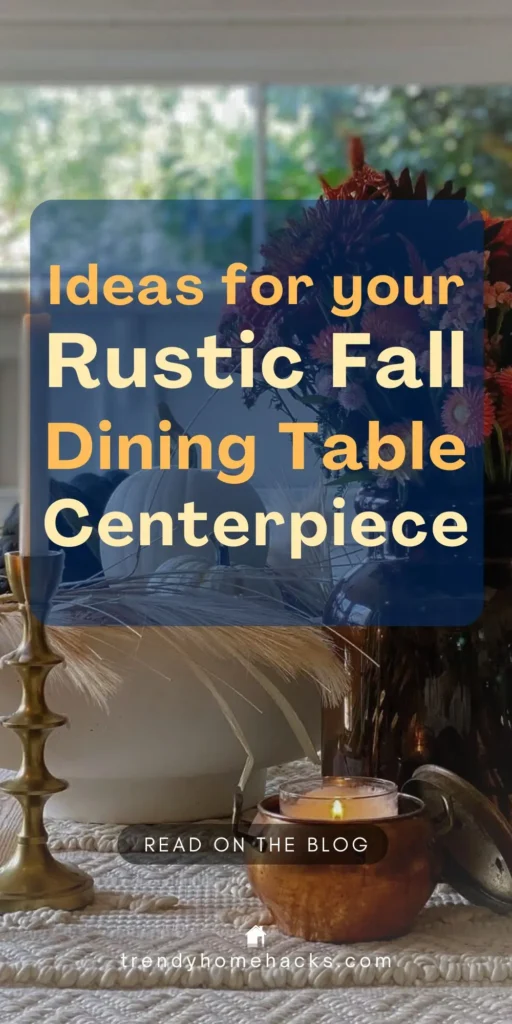 Rustic fall dining table with a cozy centerpiece featuring a brass candlestick, white pumpkin, amber glass vase with autumn flowers, and a small copper candle. Text overlay reads “Ideas for your Rustic Fall Dining Table Centerpiece.”
