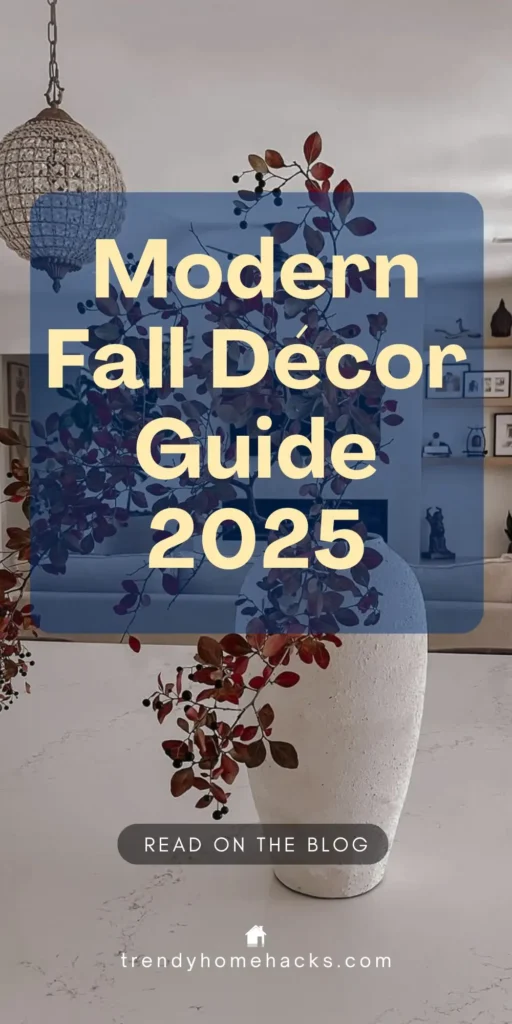 Modern fall home decor featuring a large white vase with deep red autumn foliage on a marble surface, with a textured pendant light and neutral living room in the background. Text overlay reads “Modern Fall Décor Guide 2025.”
