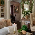 Elegant living room with a sofa, decorative pillows, lit candle, potted plant on a wooden table, large ornate mirror, and floral arrangements—carefully styled to avoid common French country decorating mistakes in a classic, cozy setting.