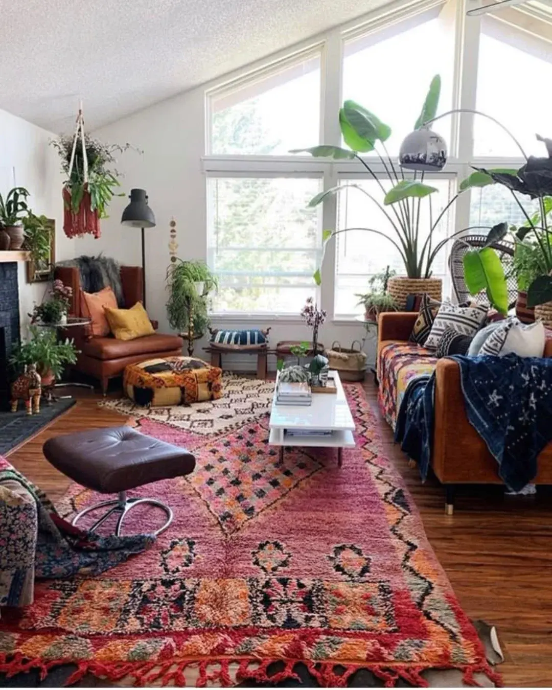 Boho living room with colorful layered rugs, lush indoor plants, and eclectic furniture. Bright space with natural light, cozy textures, and global-inspired decor creating a relaxed, inviting atmosphere.
