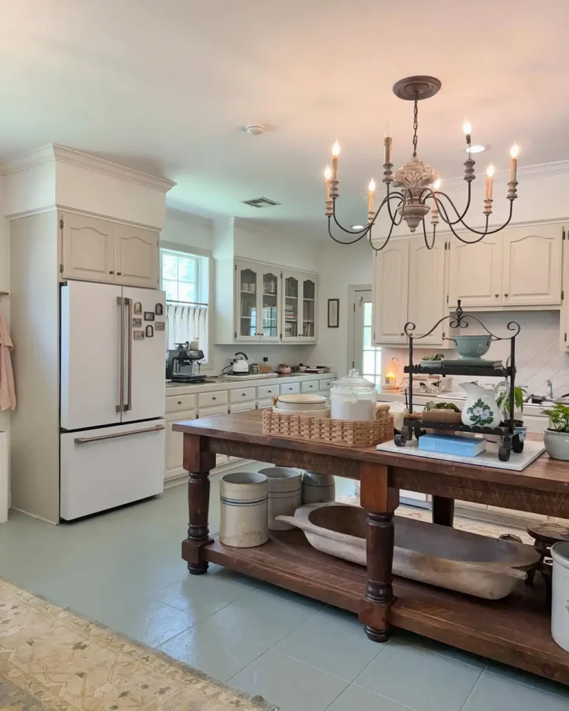 French country kitchen blending old-world charm with modern function, featuring a rustic wood island, creamy cabinetry, vintage chandelier, and high-end appliances for a timeless yet practical design.