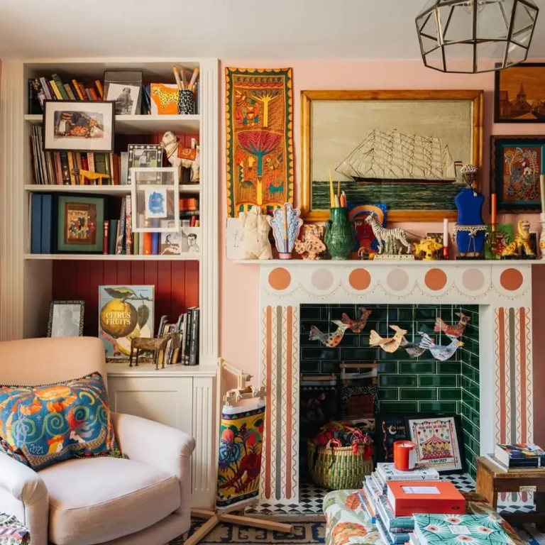 A colorful, maximalist fall living room features a decorated fireplace, shelves of books and art, a patterned armchair, and eclectic ornaments and framed artwork scattered throughout the vibrant space.