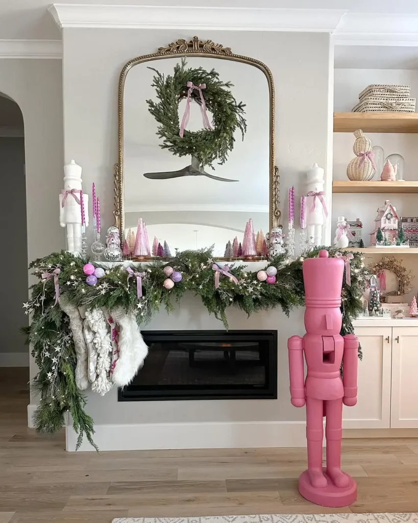 Whimsical Christmas mantel decorated with pastel pink and purple ornaments, a lush green garland with ribbons and fairy lights, a gold mirror topped with a wreath, and oversized pink and white nutcracker figures for a playful holiday look.