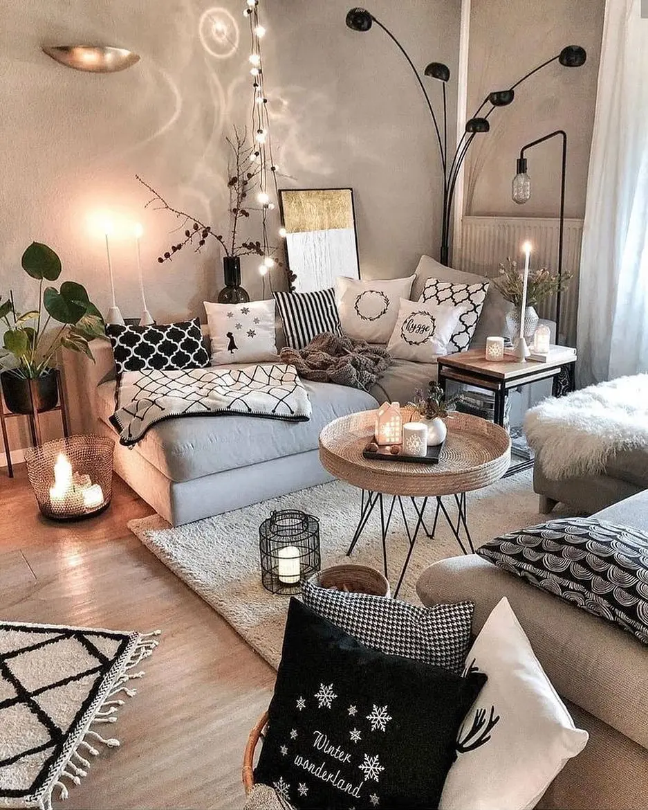 Cozy winter living room decor ideas with neutral tones, patterned pillows, candles, plants, soft lighting, and a mix of modern and rustic decor elements.